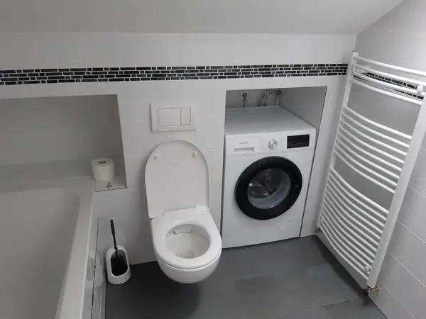 Badezimmer mit Wand-WC, Waschmaschinennische und Handtuchheizkörper